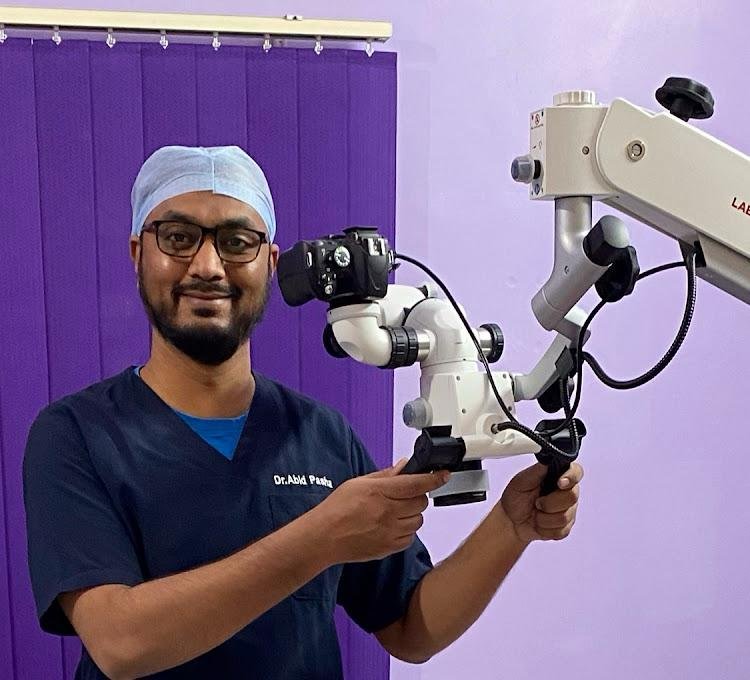 Dr. Abid Pasha at work under the dental operating microscope
